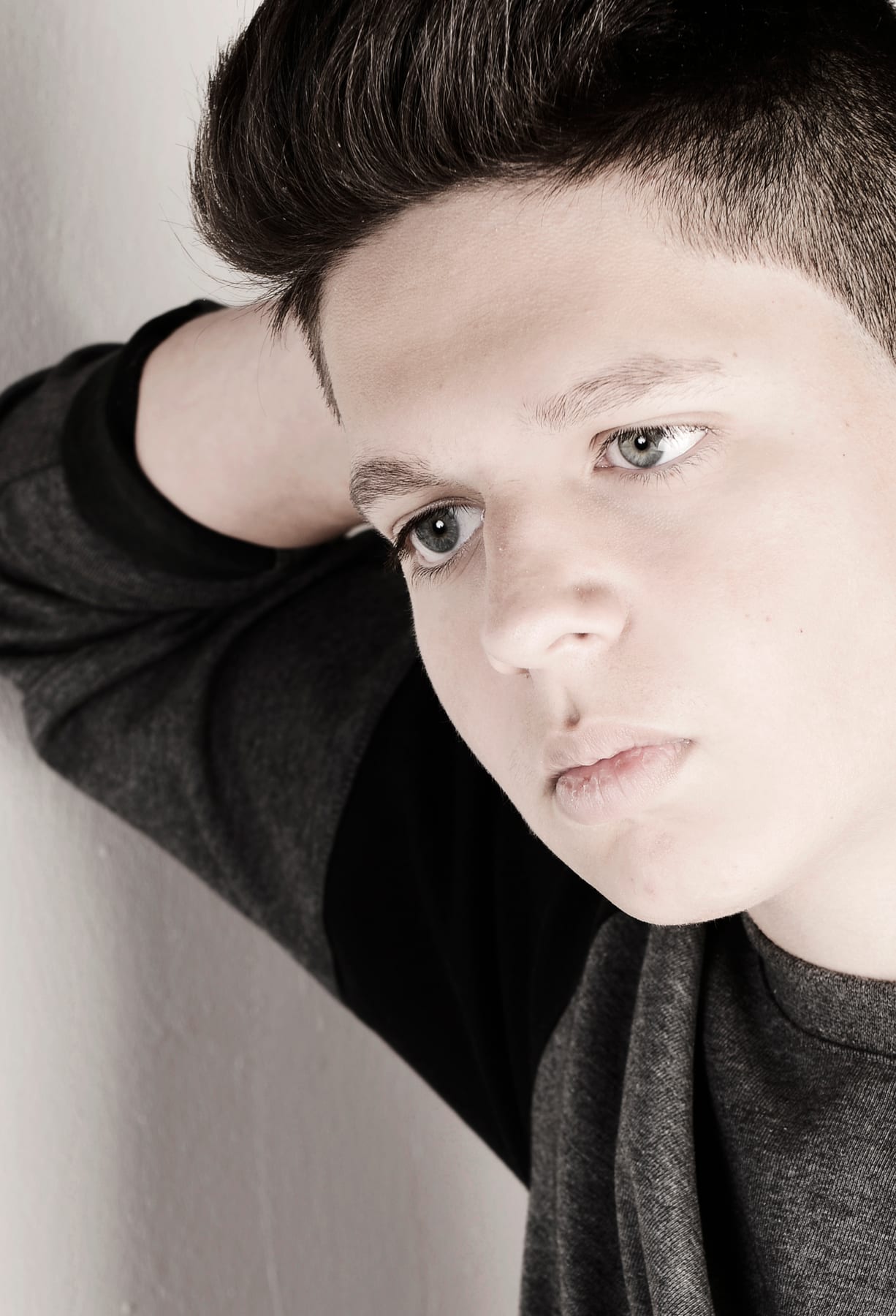 Junger Mann lehnt an einer Wand